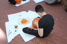 Male student carving pumpkin