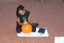 Female student carving pumpkin