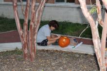Student carving pumpkin
