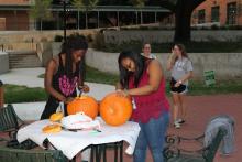 Students carving pumpkins on a table