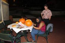 Students carving pumpkins at night