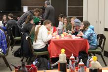 Students eating pancakes and drinking orange juice