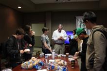 Dr. Duban talking to students getting bagels