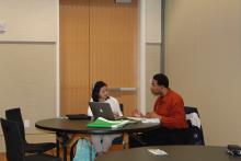 A staff member discussing a paper with a student