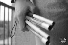 Black and white photo of a hand holding a disassembled cane.